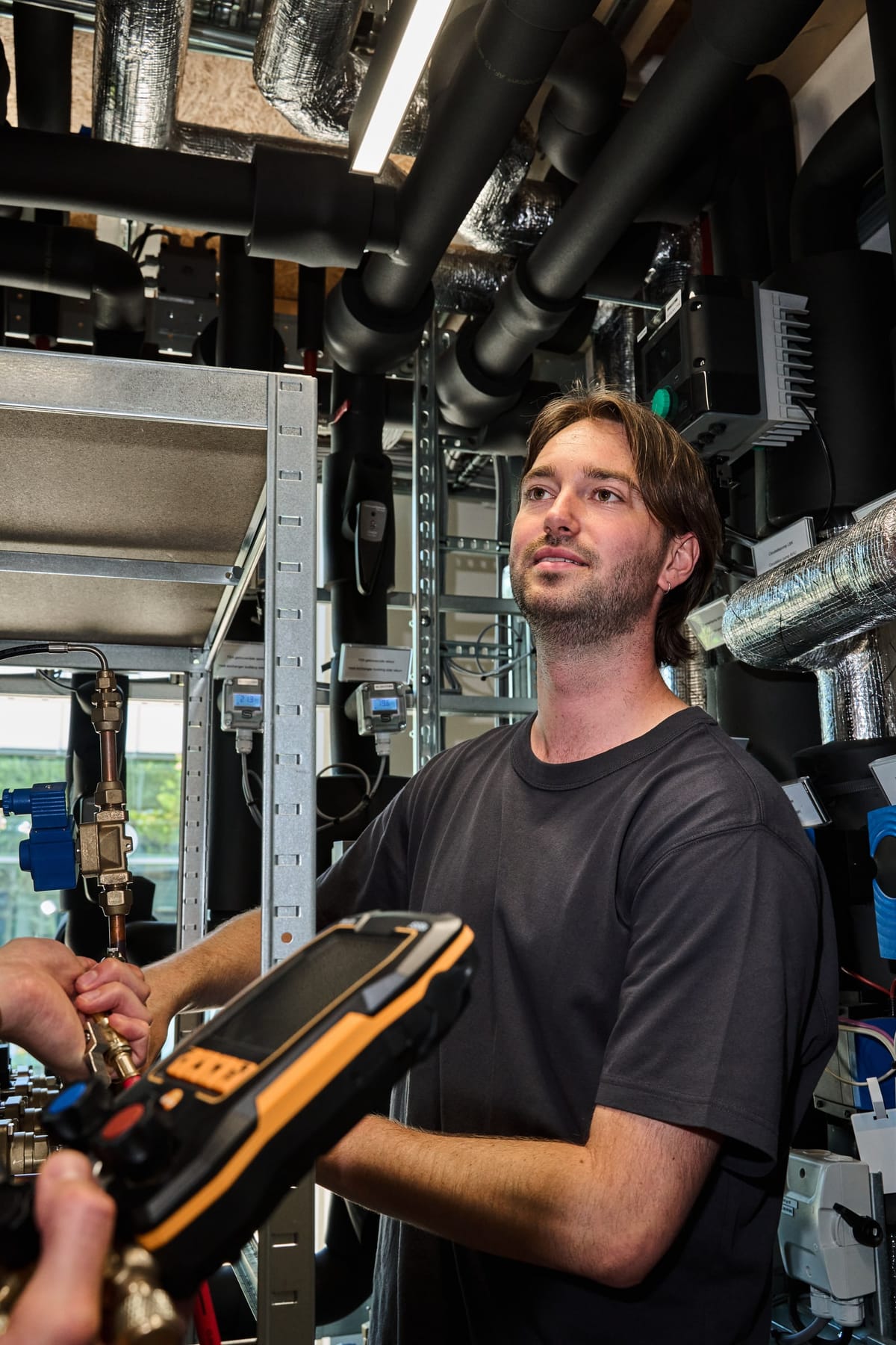 Sake Smits reading a digital refrigeration manifold gauge in the test lab