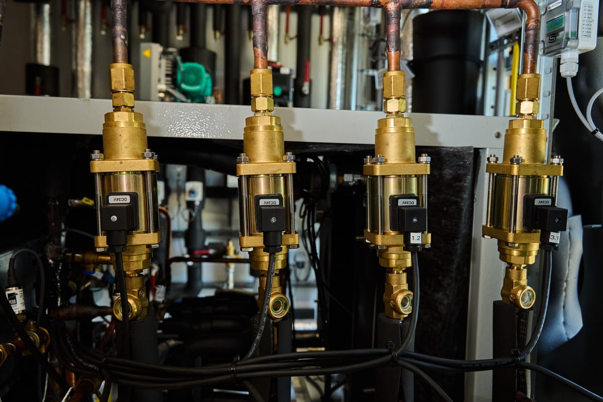 Row of four brass valve assemblies with solenoid actuators on the Expantec test rig