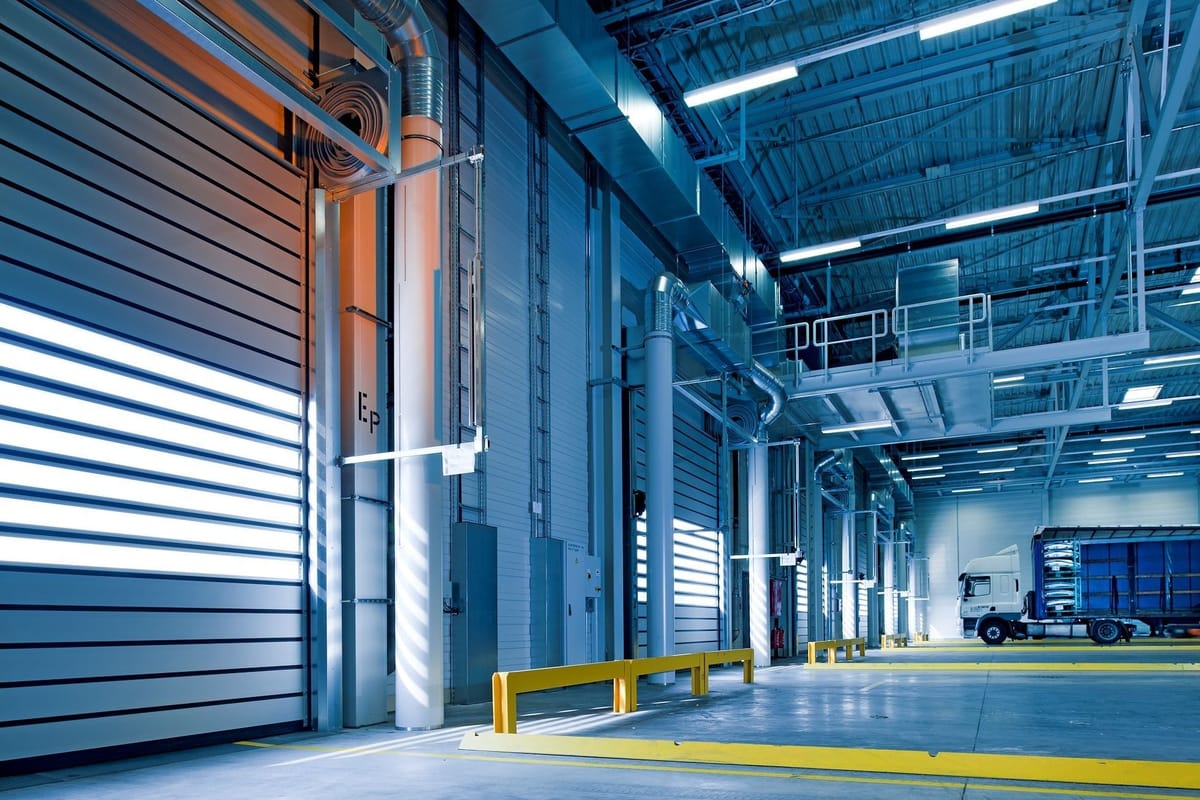 Loading bay of a modern distribution warehouse with high-speed doors and a lorry at the dock